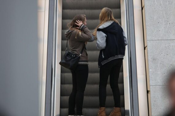 Junge Mädchen auf Rolltreppe symbolisieren die unsichere Zukunft und konsumreduzierte Gesellschaft Deutschlands.