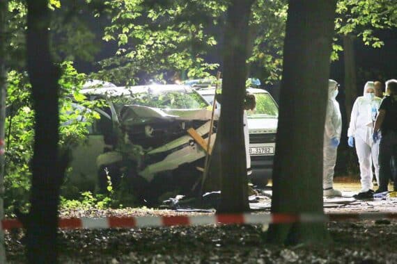 Kleintransporter am Berliner Tiergarten nach CSD-Attacke, Ermittler und Absperrung, CSD-Menschenmenge im Hintergrund.