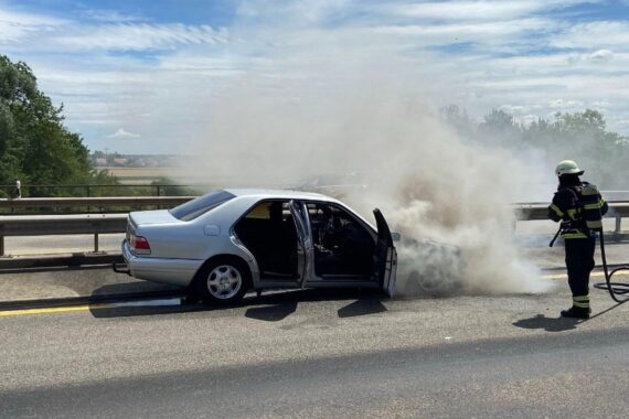 Brennendes Auto auf Autobahn, Feuerwehr im Einsatz, vorübergehende Sperrung.