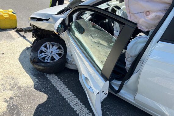 Unfall: beschädigter VW Polo und Lamborghini kollidieren an Einmündung; Einsatzkräfte sichern die Unfallstelle.