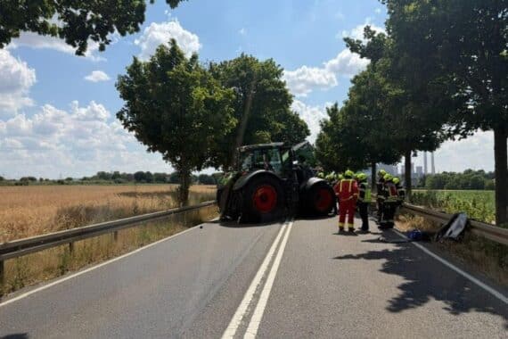 Feuerwehr an Unfallstelle: Frontalzusammenstoß Traktor und Pkw, Pkw stark deformiert, Rettungskräfte.
