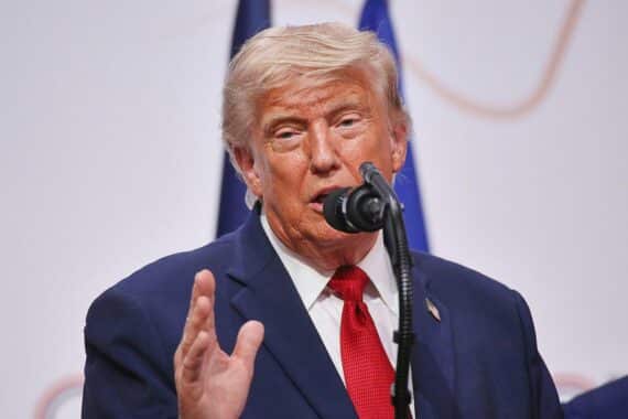 Donald Trump vor Karte der Straße von Hormus, symbolisch mit Schiffen und Sicherheitsgebühren.