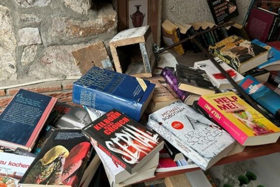 Beschädigte Vertrauenskasse im Hof, neben Büchertisch; Polizei ermittelt nach Diebstahl.