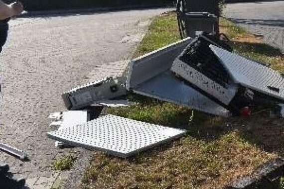Zerstörte E-Ladesäule auf Parkplatz, beschädigter Verteilerkasten; Polizei ermittelt nach Unfallflucht.