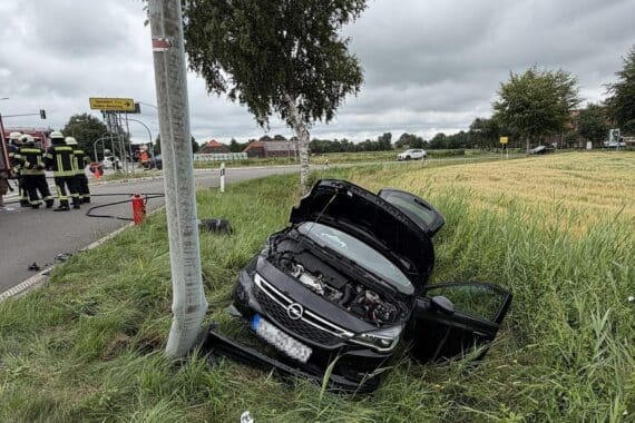 Zwei Unfallwagen nach Frontalzusammenstoß: einer im Straßengraben, Feuerwehrkräfte sichern die Unfallstelle.