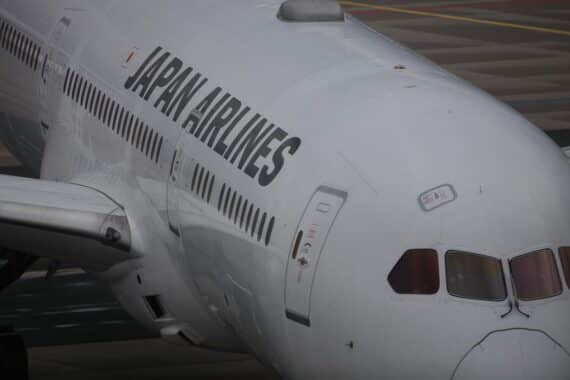 Ein Flugzeug der Japan Airlines vor einem modernen Flughafen im Japan.