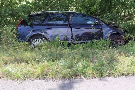 Ford Focus im Straßengraben bei Bad Driburg, Rettungskräfte behandeln den leicht verletzten Fahrer.