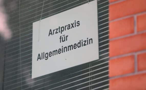 Ärztliche Praxis mit Allgemeinmediziner im Wartezimmer (Archivfoto) – Arbeitsministerin Bas diskutiert Attestpflicht.