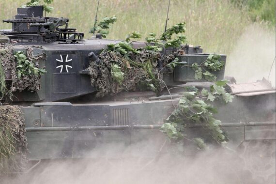 Bundeswehr-Panzer „Leopard 2“ vor Berlinkulisse, Hinweis auf KNDS-Börsengang und mögliche Staatsübernahme.