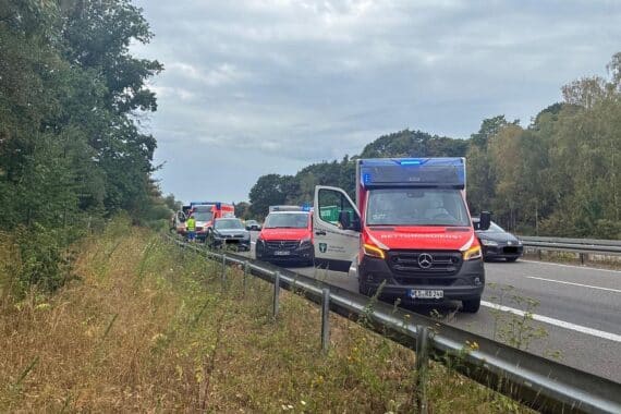 Verkehrsunfall auf der A57 bei Sonsbeck: zwei Autos, Einsatzfahrzeuge der Feuerwehr, Verletzte und abgesperrter Fahrstreifen.