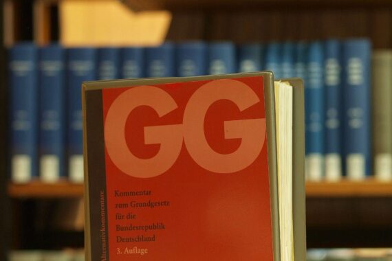 Ausgabe des Grundgesetzes in einer Bibliothek; Verfassungsrecht, Wissenschaftsfreiheit und Forschung an Hochschulen und Instituten.