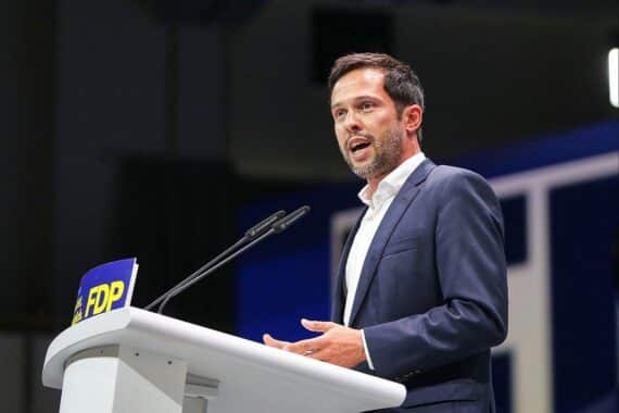 Martin Hagen vor Berliner Hintergrund, FDP-Politiker kritisiert Reformmangel in der Wirtschaftskrise.