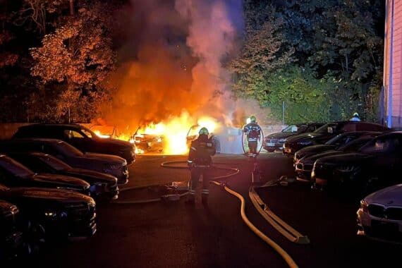 Feuerwehr im Einsatz: brennende Autos auf Hinterhof in Paderborn, Löscharbeiten mit Atemschutz und C-Rohren.