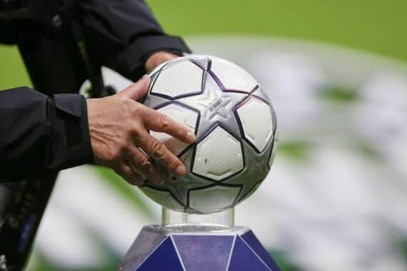 Fußballstadion im Archiv; FIFA-Präsident Gianni Infantino im Hintergrund, Proteste und Kritik in Europa angedeutet.