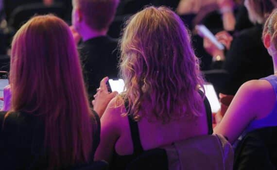 Junge Leute mit Smartphones; Diskussion über KI-Entkleidungs-Apps und Verbot, Archivfoto.