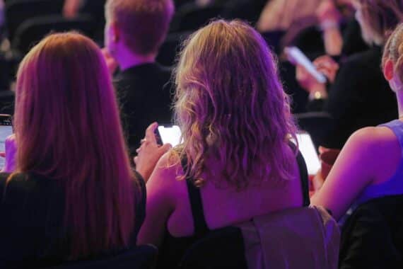 Junge Leute mit Smartphones; Diskussion über KI-Entkleidungs-Apps und Verbot, Archivfoto.