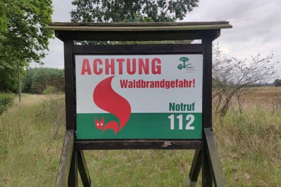 Warnhinweis zur Waldbrandgefahr im Archiv: brennender Wald, Rauch und drohende Flammen.
