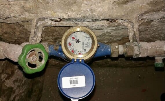 Absperrhahn und Wasseruhr im Altbaukeller—Symbol für Trinkwasserversorgung unter zunehmendem Grundwasserstress.