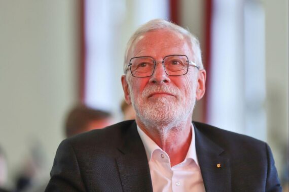 Kulturminister Rainer Robra übergibt einen Förderbescheid vor dem Stendaler Dom.