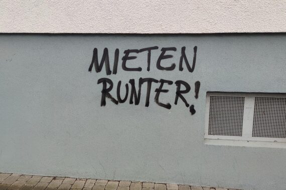 Graffiti-Schriftzug „Mieten runter“; Symbol für bezahlbares Wohnen und Recht auf Wohnen nach Pantisano.