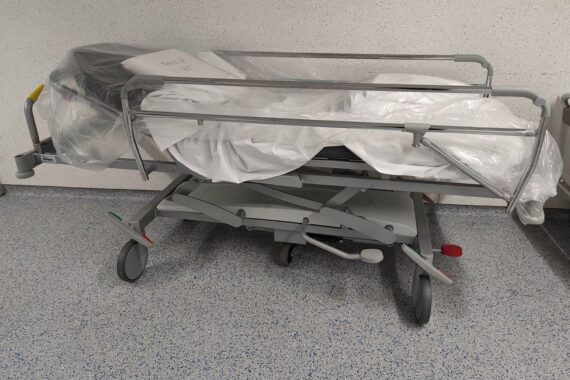 Krankenhaus-Archiv: Ärzte und Patient vor Klinik, Fokus auf Transparenz bei Behandlungsfehlern.