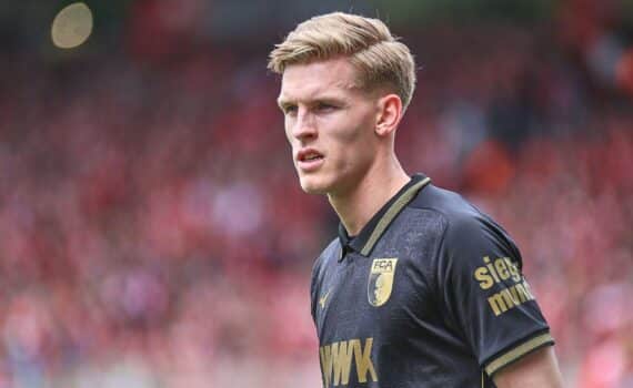 Fußballspieler (Anton Kade) jubeln vor dem FC Augsburg-Logo; Spiel: Augsburg gewinnt gegen Schalke 3:0.