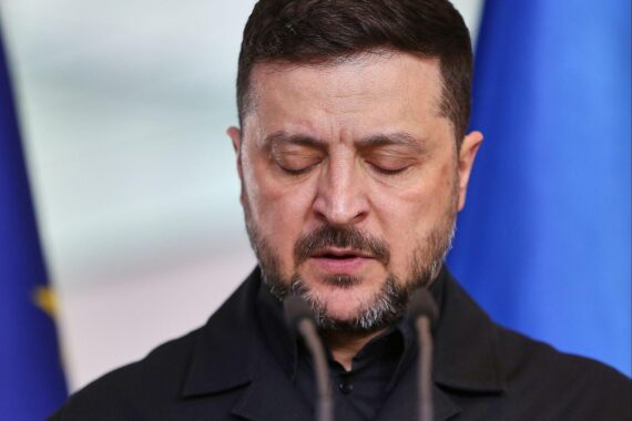 Wolodymyr Selenskyj (Archiv) vor Bildern von Schäden durch russische Angriffe in der Ukraine.