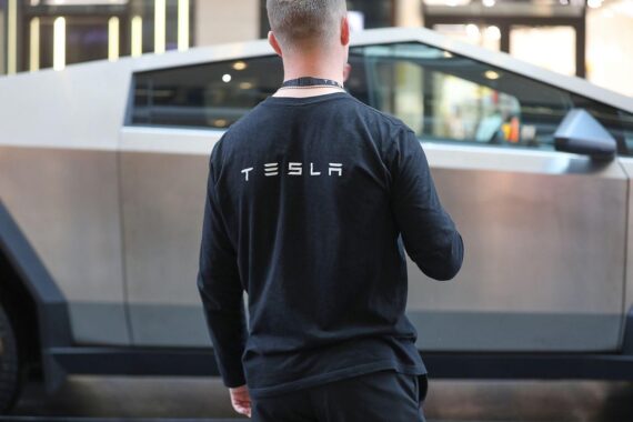 Tesla-Mitarbeiter vor dem Cybertruck; Studie zeigt schwächeren Tesla-Zuspruch in Deutschland.