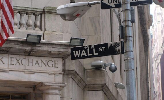 Wallstreet-Skyline mit Börsenkursen: Dow, S&P 500, Nasdaq im Plus, Gold steigt, Öl fällt.