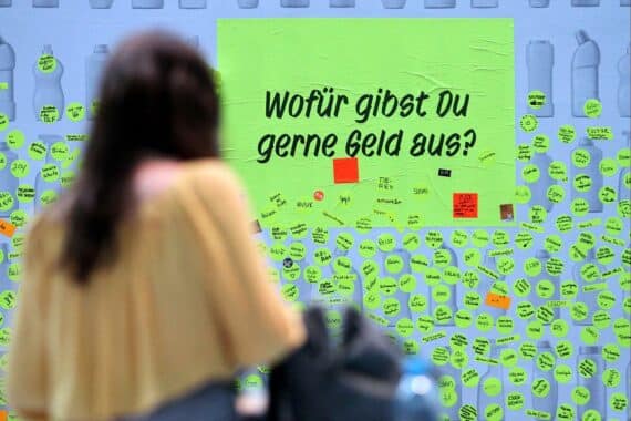 Menschen mit Stiften an einer Brainstorming-Wand, Thema Konsumklima, Einkommenserwartungen und Konjunktur.