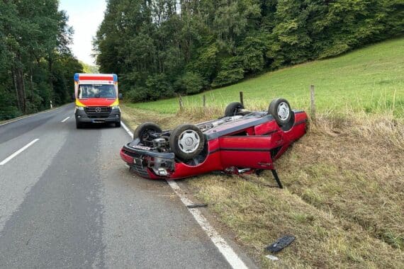 Unfallstelle: liegendes Auto im Graben, Rettungsdienst und Polizei an der Bundesstraße 410.