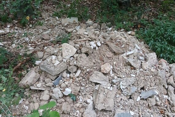 Bauschutt (Archiv) und illegale Müllablagerung bei Feldweg, nahe Sportplatz/Landesstraße; Polizei ermittelt.