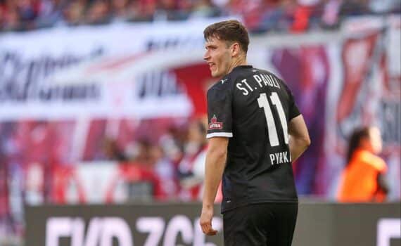 Fußballspiel: Arminia Bielefeld vs. FC St. Pauli 2:2, Torjubel von Spielern im nassen Stadion.