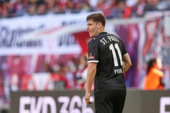 Fußballspiel: Arminia Bielefeld vs. FC St. Pauli 2:2, Torjubel von Spielern im nassen Stadion.
