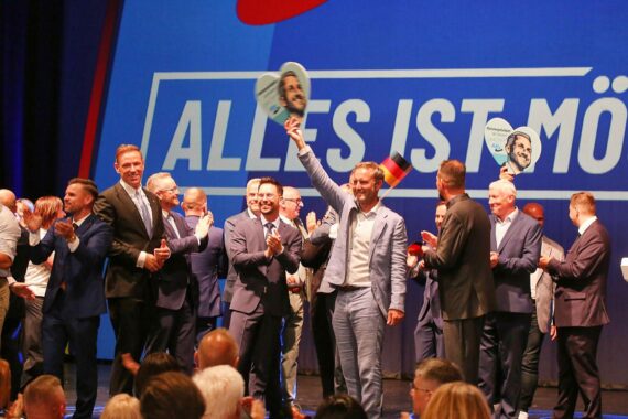 AfD-Wahlparty am 06.09.2026: Parteianhänger feiern den Erfolg, vermutlich mit Plakaten und Wahlkampf-Fotos.