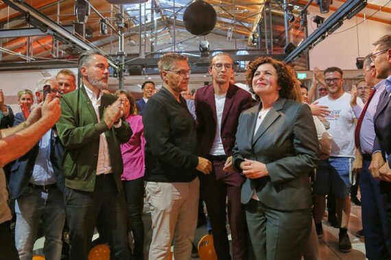 BSW-Wahlparty in Magdeburg: Kandidatin Claudia Wittig feiert Wahlabend, vor Hintergrund mit Wahlwerbung und Zuschauern.