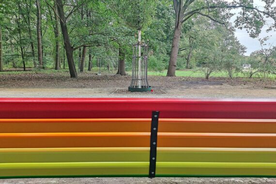 Beschädigte Regenbogenbank im Berliner Tiergarten, mehrere Holzlatten demoliert; Polizei ermittelt.