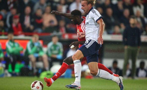 Union Berlin gegen Schalke 04, Spielstand 2:1 am 11.09.2026; Fußballer im Zweikampf, Fans im Hintergrund.