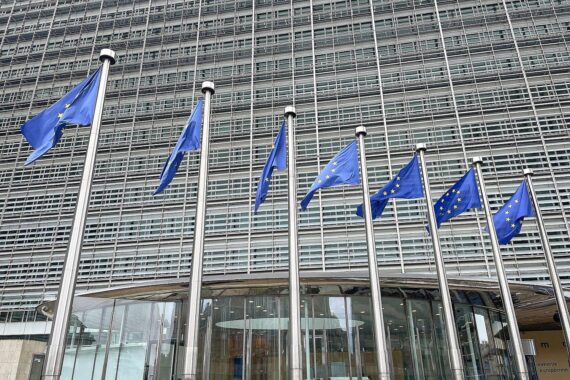 EU-Fahnen vor Regierungsgebäude: Änderungen an der EU-Verpackungsverordnung, entbürokratisierender Umweltomnibus.