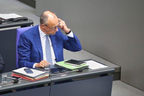 Friedrich Merz spricht, im Hintergrund CDU-Kontext, Konflikt mit CDU-Mitgliedern über Politikwechsel.