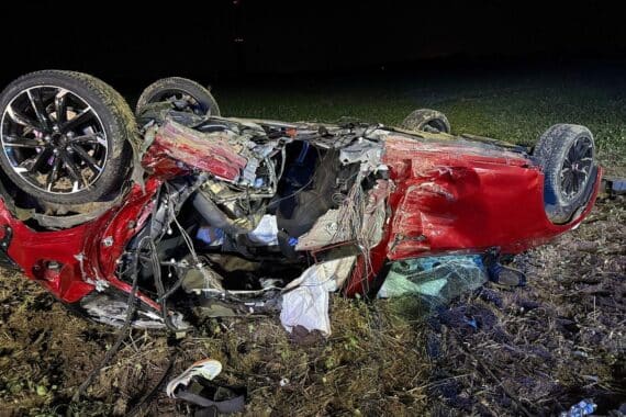 Verkehrsunfall in Kalkar: drei Autos/Personen verletzt, Feuerwehr absichert Unfallstelle, Pkw im Feld auf dem Dach.