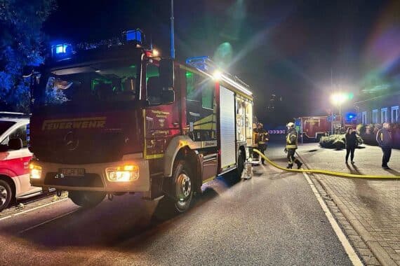 Feuerwehr im Einsatz am Wohngebäude: Rauchentwicklung, Einsatzkräfte suchen nach Ursache, Rettungskräfte vor Ort.