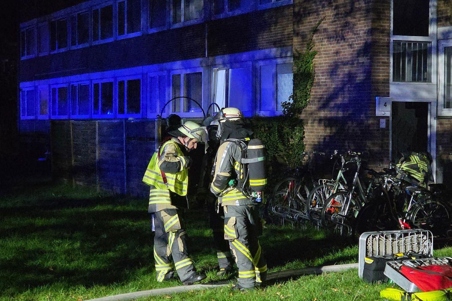 Feuerwehreinsatz bei Kellerbrand: verraucherter Mehrfamilienhaus-Treppenraum, Rettungskräfte versorgen Bewohner.
