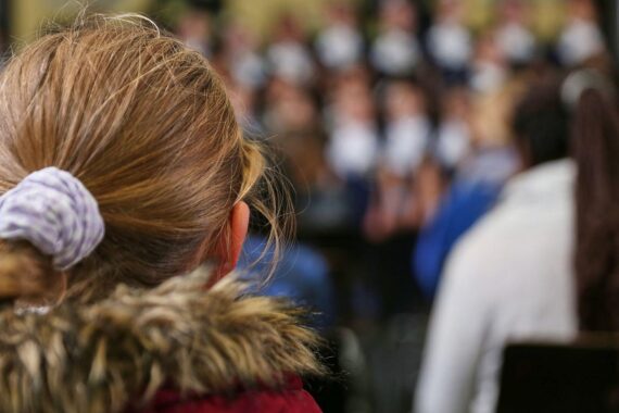 Kinder in einer Schule im Archiv, im Hintergrund politischer Streit um Familienleistungen und Kindergeld-Sparpläne.