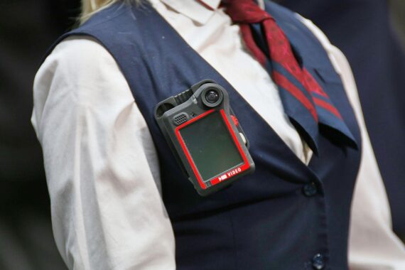 Schaffnerin mit Bodycam (Archiv) in einem Bahnhof, Symbol für strengere Strafen bei Angriffen auf Bahnpersonal.