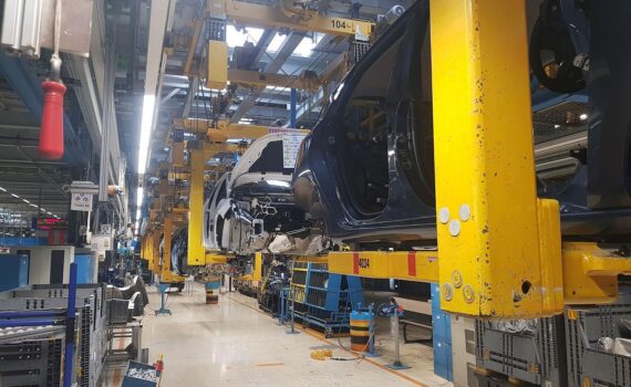 Christiane Benner bei einer Kundgebung im VW-Werk, im Hintergrund Autoproduktion/Industriearbeiter (Archivfoto).