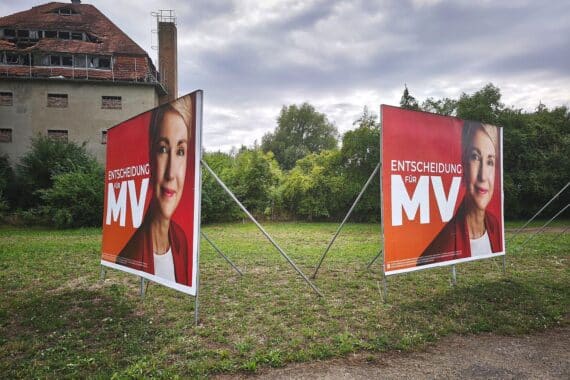 Wahlplakate mit Manuela Schwesig und SPD-Motiv, im Hintergrund Umfragewerte zur Landtagswahl 2026.