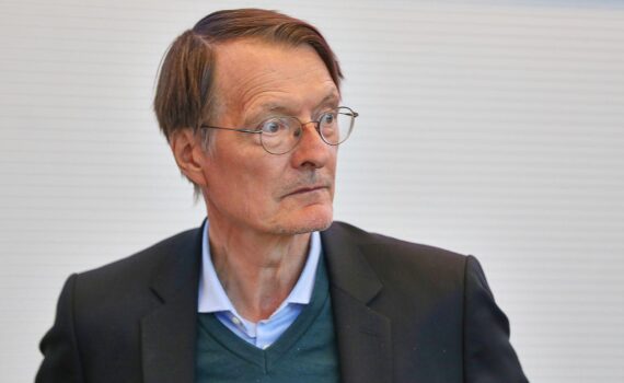 Karl Lauterbach steht vor Pressefoto, im Hintergrund Berlin, dts Nachrichtenagentur-Logo, Fokus auf SPD-Politiker.