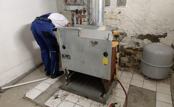Ausbau einer alten Gasheizung: Arbeiter montieren Heizungsanlage, Branche Sanitär-Heizung-Klima im Fokus.