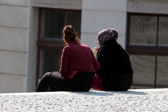 Zwei Frauen, eine mit Kopftuch, eine ohne, symbolisch für Asylbewerberleistungen in Rheinland-Pfalz.